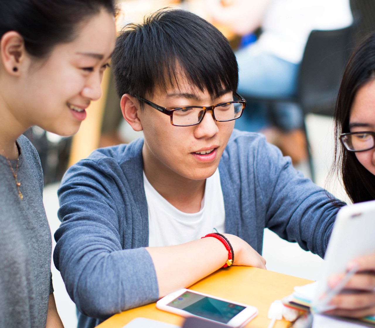 Undergraduate publications Students looking at information on a mobile phone