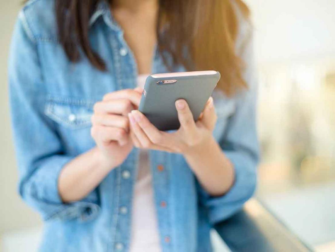 Student sending a message on their mobile phone